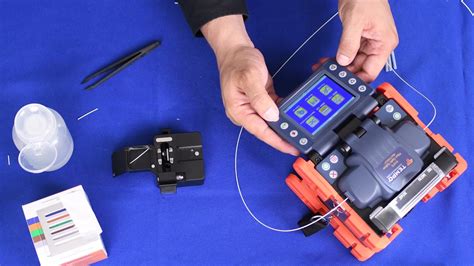 Una imagen que muestre una fusionadora de fibra óptica en acción, con dos fibras siendo unidas por un arco eléctrico.