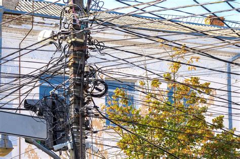 Fotografía de un poste de telecomunicaciones con varios cables anclados