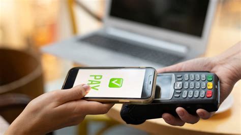 Una persona usando su teléfono móvil para pagar en un terminal contactless