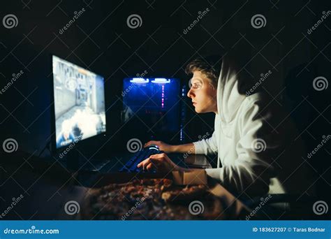 Imagen de un gamer concentrado jugando en un ordenador con una conexión de fibra óptica.