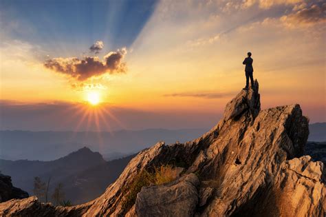 Montañista utilizando una radio en la cima de una montaña