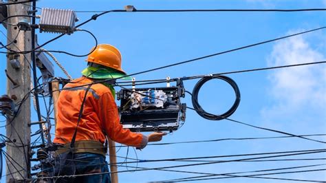 maestro liniero instalando fibra óptica en poste