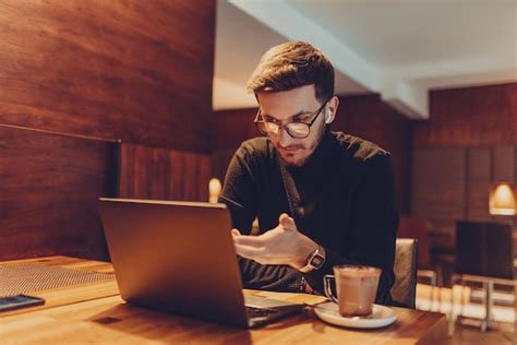 Persona trabajando en una cafetería con una laptop y un café